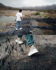 a man standing on top of a rock next to a body of water