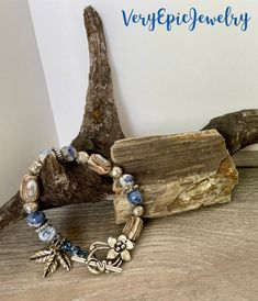 Rustic Beaded Gemstone Bracelet Handmade Ceramic Beads and Blue Sodalite Beads Artisan Boho Style Jewelry  A mottled blue and white sodalite gemstone bead along with handmade ceramic beads are the focal of this rustic artisan boho style bracelet. Sprinkled in are silver tone spacer beads in various shapes and sizes. A beautiful silver tone flower toggle clasp holds it closed.  As you may have noticed, I love dangles and this bracelet has three silver tone leaf charms to add more interest, balance and fun!    This statement bracelet will capture the eye - and imagination - everywhere you go; a Boho  treasure that was created by me, @VeryEpicJewelry!  Bracelet measures 8 1/2" long Adjustable Lapis Lazuli Beaded Bracelets Bohemian Style, Blue Bohemian Beaded Bracelets For Meditation, Bohemian Blue Beaded Bracelets For Meditation, Bohemian Lapis Lazuli Beaded Bracelets, Bohemian Beaded Bracelets With Lapis Lazuli Stones, Bohemian Lapis Lazuli Beaded Bracelets With Natural Stones, Bohemian Beaded Bracelets With Lapis Lazuli, Bohemian Lapis Lazuli Beaded Bracelets As Gift, Nature-inspired Adjustable Beaded Bracelet With Round Beads