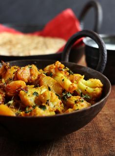 two bowls filled with food on top of a wooden table