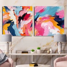 two paintings on the wall in a living room with pink chairs and a coffee table