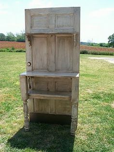 an old wooden cabinet sitting in the grass