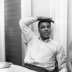 a black and white photo of a man sitting at a table with his hands on his head