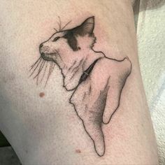 a black and white cat tattoo on the thigh