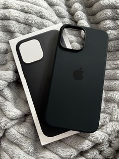 two iphone cases sitting on top of a blanket