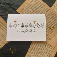 some paper with christmas trees on it and gold stars around the edges that read merry christmas