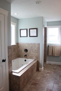 a bathroom with a large bathtub next to a window