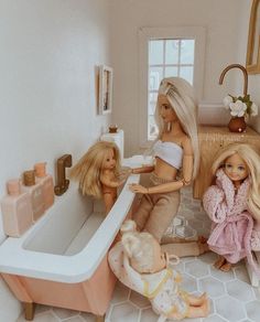 two barbie dolls are playing in the bathroom