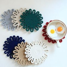 three plates with different designs on them and an egg in a bowl next to each other