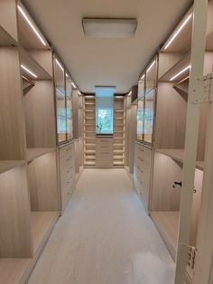 an empty walk - in closet with lots of shelves and drawers on the walls,