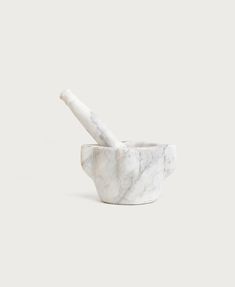 a marble mortar and pestle set on a white background with the tip pointing up