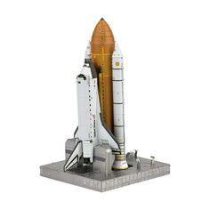 a model of the space shuttle is shown on a white surface with an orange rocket attached to it