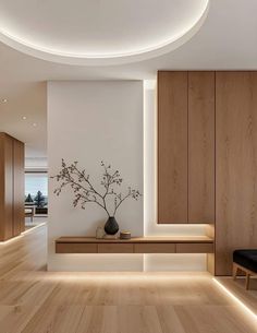 a modern living room with wood floors and white walls, lighted by recessed lighting