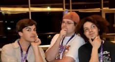 three young men sitting next to each other