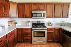 a kitchen with wooden cabinets and stainless steel stove top oven in the middle of it