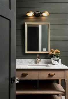 a bathroom sink sitting under a mirror next to a wooden cabinet with drawers underneath it