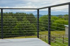 an outdoor deck with metal railings and trees in the background