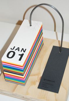 a stack of colorful cards sitting on top of a wooden block with a metal handle