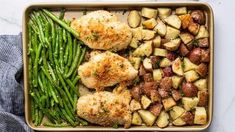 chicken, potatoes and green beans in a casserole dish on a marble surface