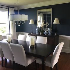 a dining room table with white chairs around it