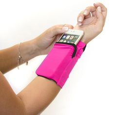 a woman is holding her cell phone and wearing a pink armband with an ipod in it