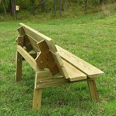 a wooden bench sitting on top of a lush green field