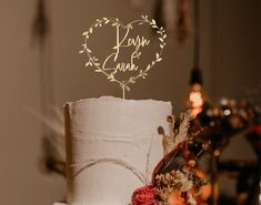 a wedding cake with a heart topper on it