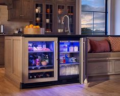 an open refrigerator in the middle of a kitchen with wooden floors and cabinets on both sides