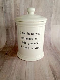 a white canister with the words i am in no way obrigated to tell you what i keep in here