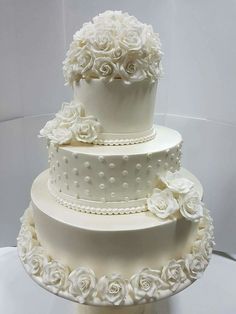 three tiered wedding cake decorated with white roses