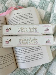 two bookmarks that are sitting on top of an open book with coffee related writing