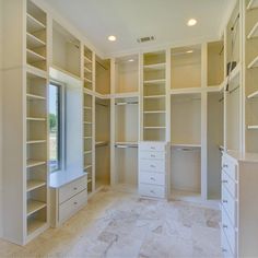 an empty walk in closet with lots of shelves