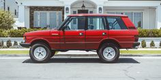 a red suv parked in front of a house