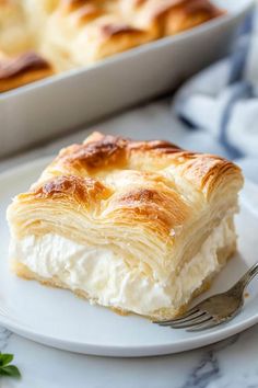 a piece of pastry sitting on top of a white plate next to a baking pan