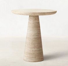 a round table made out of concrete sitting on top of a white floor