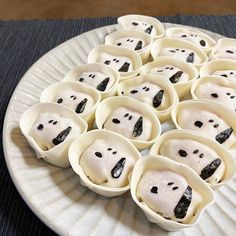 there are many dumplings on the plate with black dots in them and one is white