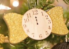 an ornament hanging from a christmas tree decorated with gold sequins and a clock