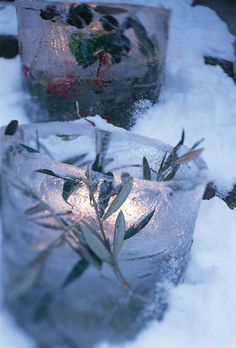 two candles are sitting in the snow covered ground