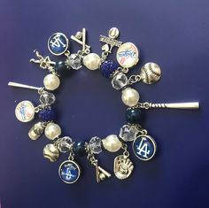 a bracelet with charms and baseballs is shown on a blue surface in this image