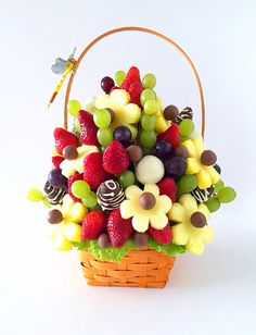 a basket filled with lots of different types of fruit and candy on top of a white table