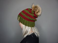 a woman with blonde hair wearing a green and red knitted beanie hat on top of her head