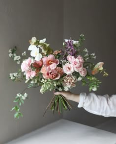 a person holding a bouquet of flowers in their hand