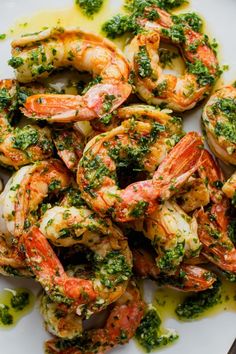 cooked shrimp with pesto and parsley on a white plate