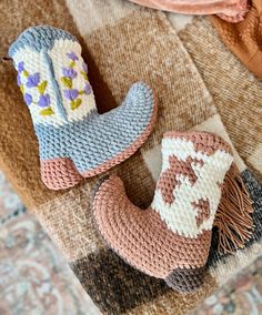 two crocheted cowboy boots sitting on top of a rug