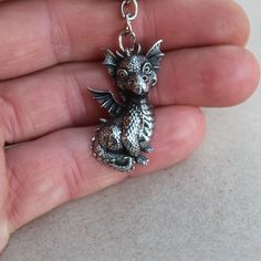 The detail of the little dragon is amazing: dragon scales, horns and spikes, the texture of the wings are worked out. Art casting, handiwork. Material: fine pewter. Dragonet height: 35 mm. The item can be used as a pendant. Excellent gift for dragons lovers! FREE SHIPPING for additional items! Gothic Metal Jewelry With Dragon Design, Collectible Metal Jewelry With Dragon Design, Metal Dragon Design Jewelry Gift, Metal Jewelry With Dragon Design As Gift, Metal Jewelry With Dragon Design For Gift, Fantasy Silver Jewelry With Dragon Design, Handmade Fantasy Silver Jewelry, Silver Fantasy Jewelry With Dragon Design, Handmade Silver Fantasy Jewelry