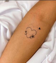 a small tattoo on the arm of a person with a heart and flowers in it