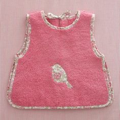 a pink bib with a bird applique on it