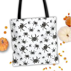 a black and white spider bag surrounded by candy corn