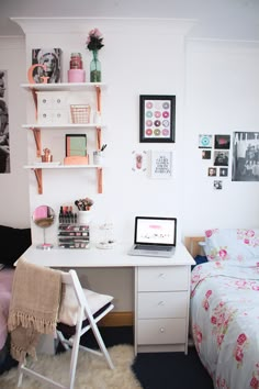 a bedroom with a bed, desk and shelves on the wall next to each other