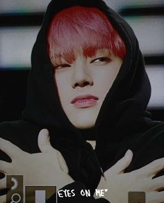 a person with red hair wearing a black hoodie