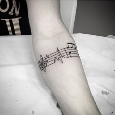 a black and white photo of a person's arm with music notes on it